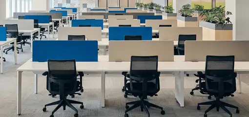 Modern open-plan office space featuring clean workstations, ergonomic chairs, and sanitized carpets provided by professional office cleaning services in Santa Ana, CA.