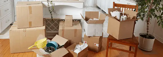 Packed moving boxes and household items in a kitchen before move-out or move-in cleaning, Santa Ana, CA.